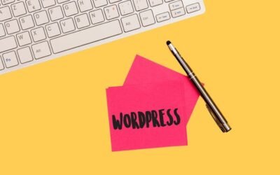 Ein rosa Notizblock mit dem Wort WordPress darauf neben einer Tastatur.